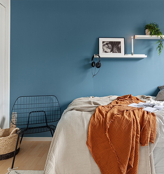 Slaapkamer in woning die te koopstaat met oranje deken
